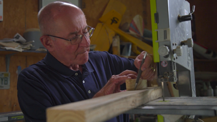 Man drawing line on wood to cut