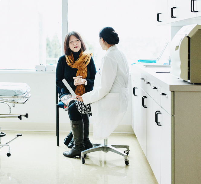 Female doctor in discussion with senior female patient in exam room.