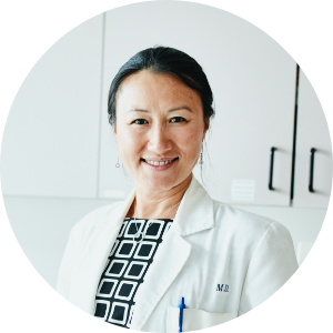 Portrait of a female physician in an exam room.